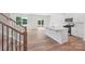 Kitchen and staircase, featuring an island with sink and white cabinets and wood flooring at 11131 Cardinal Creek Ave, Charlotte, NC 28215