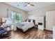 Bright bedroom featuring hardwood floors, vanity with lighted mirror, and a comfortable bed at 113 Dairy Farm Rd, Mooresville, NC 28115