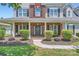Close-up view of the home's entrance featuring a brick porch, elegant front door with wreath, and manicured landscaping at 113 Dairy Farm Rd, Mooresville, NC 28115