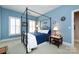 Serene bedroom with blue walls, a four-poster bed, and ample natural light from shuttered windows at 139 Harper Lee St, Davidson, NC 28036