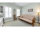 Light-filled bedroom with a futon sofa, two windows, and neutral-toned walls at 139 Harper Lee St, Davidson, NC 28036