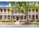 Charming brick townhome with inviting front porch and patriotic American flags on display at 139 Harper Lee St, Davidson, NC 28036