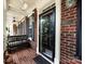 Inviting front porch featuring brick flooring, black bench, and classic ceiling fan for relaxation at 139 Harper Lee St, Davidson, NC 28036