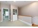 Upstairs hallway with neutral carpeting, a built-in bookcase, and doorways to adjacent rooms at 139 Harper Lee St, Davidson, NC 28036