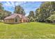 Expansive backyard with lush lawn, mature trees, and patio; perfect for entertaining at 13930 Wild Heather Ct, Charlotte, NC 28273