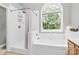 Bright bathroom features a soaking tub under a large window and a separate shower with white tile at 13930 Wild Heather Ct, Charlotte, NC 28273