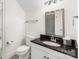 Bathroom with a single sink vanity featuring a dark countertop and a mirrored medicine cabinet at 15216 Ballantyne Country Club Dr, Charlotte, NC 28277