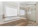 Primary bathroom featuring tiled floors, a jacuzzi tub and a glass enclosed shower at 15216 Ballantyne Country Club Dr, Charlotte, NC 28277