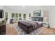A bright bedroom featuring a large bed, neutral carpeting, large windows, and white trim at 15216 Ballantyne Country Club Dr, Charlotte, NC 28277