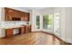 Bright dining area featuring hardwood floors, large windows, and built-in cherry cabinetry with a white countertop at 15216 Ballantyne Country Club Dr, Charlotte, NC 28277