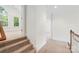 Hallway with stairs leading up to the second floor landing of this bright and airy home at 15216 Ballantyne Country Club Dr, Charlotte, NC 28277