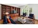 Bright living room boasts hardwood floors, stylish furnishings, built-in shelving, and large window at 15216 Ballantyne Country Club Dr, Charlotte, NC 28277