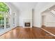 Open living room featuring a fireplace, hardwood floors, and access to the staircase at 15216 Ballantyne Country Club Dr, Charlotte, NC 28277