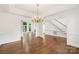 Bright living area featuring hardwood floors, staircase, and elegant chandelier at 15216 Ballantyne Country Club Dr, Charlotte, NC 28277