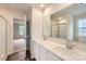 Well-lit bathroom featuring a double sink vanity with white cabinets, a large mirror, and a glass-enclosed shower at 1545 Cottage Creek Dr, Bessemer City, NC 28016