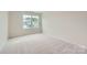 Comfortable bedroom featuring plush carpet, fresh paint, natural light, and a window overlooking the neighborhood at 1545 Cottage Creek Dr, Bessemer City, NC 28016