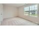 Cozy bedroom with neutral carpet, a window with outdoor views, and fresh paint, perfect for rest and relaxation at 1545 Cottage Creek Dr, Bessemer City, NC 28016