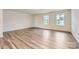 Bright living room featuring beautiful flooring, fresh paint, large windows, and an exterior door to the backyard at 1545 Cottage Creek Dr, Bessemer City, NC 28016