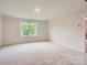 Spacious main bedroom with plush carpet, neutral paint, a large window, and an ensuite bathroom at 1545 Cottage Creek Dr, Bessemer City, NC 28016