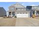 Charming two-story home featuring a stone facade, gray siding, and a two-car garage at 1708 Speartip Ln, Denver, NC 28037