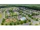A scenic aerial view of a residential neighborhood showcasing tree-lined streets, homes, a pool, and a park at 1814 Still Water Ln, Fort Mill, SC 29707