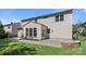 The backyard features manicured green grass, a beautiful patio, and mature trees at 1814 Still Water Ln, Fort Mill, SC 29707