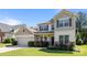 Inviting two-story home featuring a manicured lawn, neutral siding, and an attached two-car garage at 1814 Still Water Ln, Fort Mill, SC 29707