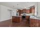Bright kitchen boasts wood cabinets, stainless steel appliances, granite countertops, and hardwood floors at 1814 Still Water Ln, Fort Mill, SC 29707