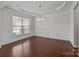 Elegant living room with hardwood floors, wainscoting, tray ceiling, and a decorative chandelier at 1814 Still Water Ln, Fort Mill, SC 29707