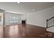 Open living room with hardwood floors, fireplace, staircase, and lots of natural light at 1814 Still Water Ln, Fort Mill, SC 29707
