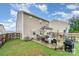 A fenced backyard features a stone patio with an outdoor kitchen and dining area, perfect for entertaining at 189 Fesperman Cir, Troutman, NC 28166