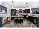 Modern kitchen featuring dark cabinets, wooden flooring, and a central island with bar seating at 189 Fesperman Cir, Troutman, NC 28166