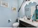 Charming powder room featuring blue walls, a decorative paddle, and a modern vanity with a dark cabinet at 189 Fesperman Cir, Troutman, NC 28166