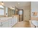 Bright bathroom featuring a double vanity, a glass-enclosed shower, and a soaking tub at 1912 Windmere Dr, Monroe, NC 28110