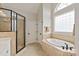 Bright bathroom features a walk-in shower, soaking tub and tiled walls at 1912 Windmere Dr, Monroe, NC 28110