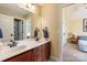 Bathroom with double sink vanity, wood cabinets, and a doorway to a bedroom at 1912 Windmere Dr, Monroe, NC 28110