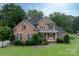 Elegant two-story brick home with a lush green lawn and manicured landscaping at 1912 Windmere Dr, Monroe, NC 28110
