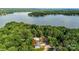 Aerial view of a home nestled among trees with a lake in the background at 2027 Marquesas Ave, Tega Cay, SC 29708