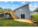A blue house with a deck, tan stairs, and a walk-out basement with a concrete patio is surrounded by a grassy yard at 2027 Marquesas Ave, Tega Cay, SC 29708