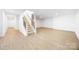 Finished basement features a staircase, neutral color scheme, and durable laminate flooring at 2027 Marquesas Ave, Tega Cay, SC 29708