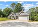 A single-story home with a two-car garage, concrete driveway, blue siding, a grey roof, and professionally landscaped front yard at 2027 Marquesas Ave, Tega Cay, SC 29708