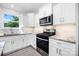 Bright kitchen with white cabinets, granite countertops, and stainless steel appliances at 2027 Marquesas Ave, Tega Cay, SC 29708