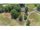 Aerial view of the property showing lush greenery and mature trees surrounding a pond and the residence at 2291 Howell Rd, Midland, NC 28107
