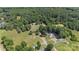 Aerial view of the property showing lush greenery and mature trees, near a pond and additional structures at 2291 Howell Rd, Midland, NC 28107