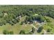 Aerial view of the property showing lush greenery and mature trees, near a pond and additional structures at 2291 Howell Rd, Midland, NC 28107