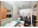 Standard bathroom featuring a shower with decorative curtains, simple vanity, and framed mirror at 2291 Howell Rd, Midland, NC 28107