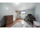 Simple bedroom with laminate flooring, window, dresser, desk, and comfortable office chair, providing a functional workspace at 2291 Howell Rd, Midland, NC 28107