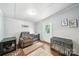 Comfortable living room area with cozy chair, dog kennels, hardwood flooring, and ample natural light at 2291 Howell Rd, Midland, NC 28107
