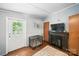 Cozy living room featuring a fireplace, flatscreen TV, doorway, and dog kennel at 2291 Howell Rd, Midland, NC 28107