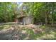Outdoor storage shed nestled in the woods, providing covered space and a concrete area at 2291 Howell Rd, Midland, NC 28107